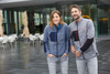 A grey polar fleece jacket featuring black and blue accents, worn by a man and woman in an outdoor setting.