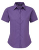 A purple short-sleeved button-up blouse with a collared neckline and a fitted silhouette. The shirt has a logo.