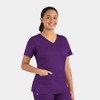 A women's double V-neck top in a vibrant purple colour, featuring short sleeves and a pocket. Includes a logo.