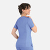 A curved mock wrap top in light blue, featuring short sleeves and a fitted design, with a logo on the garment.