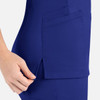 A women's curved mock wrap top in a vibrant blue colour, featuring pockets and a side slit detail.