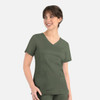 A mock wrap top in dark green with short sleeves and two front pockets. It features a logo on the side.