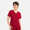 A red women's curved mock wrap top featuring short sleeves and two front pockets, with a logo present.