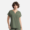 A women's olive green dolman top featuring a V-neck and three pockets, with a logo on the side.