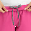 A pair of pink women's joggers with a grey drawstring at the waist and a logo present.