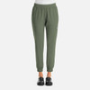 A pair of women's joggers in olive green with an elastic waistband and side pockets. Features a logo on the leg.
