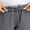 A close-up of grey women's yoga waist joggers featuring a drawstring waistband and a logo.