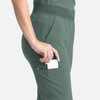 A green women's flare leg pant with an elastic waistband and a side pocket. It features a logo on the pant.