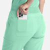 A pair of mint green flare leg pants with an elastic band and a phone tucked in the back pocket.