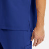 A close-up of a men's tuckable V-neck top in blue, featuring a side slit and visible stitching details.