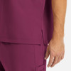 A maroon tuckable V-neck top featuring side slits, showing part of the sleeve and a hand.