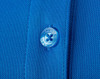 A close-up of a blue polo shirt featuring textured fabric and a button with a logo.