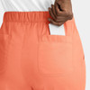 A pair of peach cargo pants with a full elastic waistband and a smartphone partially visible in the pocket.