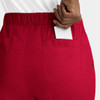 A pair of red cargo pants featuring a full elastic waistband and a back pocket holding a white card.