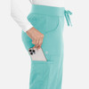 A pair of teal women's joggers featuring pockets and a drawstring waist, with a phone being placed in one pocket.
