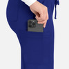A woman's hand placing a smartphone into the pocket of blue cargo pants. The pants feature a sleek design with a logo.