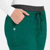 Women's cargo pants in teal with a contrasting grey waistband and pocket details. Features a logo on the fabric.