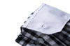 A folded ladies checked blouse featuring a black and white pattern with a white collar and button details.