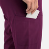 A close-up of a women's jogger in a deep purple colour, featuring a side pocket with a hand placing a card inside.
