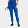 Bright blue women's jogger pants with cuffed hems, an elastic waistband, and pockets, paired with black athletic shoes.