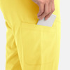 A pair of yellow joggers featuring a pocket with a hand placing a phone inside.