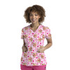 A pink women's V-neck top featuring a playful print of cartoon characters and hearts, with two front pockets.