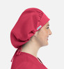 A unisex bouffant cap in vibrant red worn by a smiling individual, featuring a logo on the side.