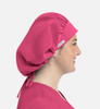 A unisex bouffant scrub cap in bright pink, featured on a model viewed from the side. It has a branding tag.