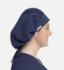 A navy unisex bouffant scrub cap displayed on a person, featuring a logo and adjustable ties at the back.