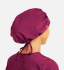 A unisex bouffant scrub cap in deep burgundy, featuring a tied back design and a smooth finish.