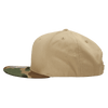 A high-profile structured snapback cap with a camo-patterned visor and a beige body. It features a logo on the side.