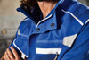 A blue workwear vest featuring a collar and several pockets, designed for durability and functionality.