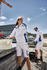 Two workers in white workwear, including a half-zip jumper, engaged in outdoor construction tasks.