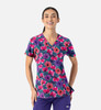 A vibrant women's V-neck top featuring a floral print in purple, pink, and green hues. It includes a logo.