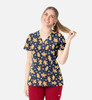 A V-neck print top featuring a navy background with gingerbread man patterns, paired with red pants.