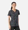 A women's v-neck top featuring a grey fabric with a playful animal print design and a logo on it.