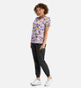 A woman models a purple v-neck print top featuring floral patterns, paired with black joggers and white sneakers.