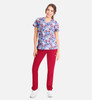 A floral V-neck print top in blue, paired with red pants, worn by a model standing against a plain background.