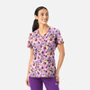 A floral women's V-neck top in purple tones, featuring short sleeves and a fitted design. It has a logo on the side.