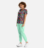 A woman poses in a vibrant floral print V-neck top with short sleeves, paired with mint green joggers.