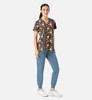 A floral V-neck top in multicolours paired with blue pants, featuring a logo on the shirt.
