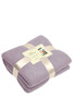 A folded purple fleece blanket, secured with a ribbon and label, displaying soft fabric texture.