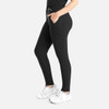 A pair of black tapered leg pants with pockets and a drawstring waist, modelled with white sneakers.