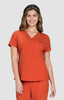An orange V-neck top worn by a smiling woman, featuring a small logo on the chest.