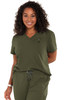A woman smiles while wearing a green "Ready to Work Top" with a pocket and a logo. The fabric appears comfortable.