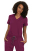 A woman is wearing a purple scrubs top with a v-neckline and short sleeves, featuring a front pocket and drawstring waist.