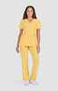 A woman wearing a bright yellow scrub top and matching pants, standing against a neutral background.