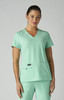 A mint green medical top with a V-neck design and two front pockets, worn by a model. It features a logo.