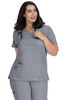 A grey medical top with a V-neck, featuring pockets and a logo, worn by a woman with shoulder-length hair.