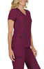 A woman is wearing a short-sleeved, v-neck top in burgundy, paired with matching pants, featuring a branding logo.